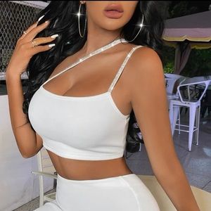 This is a two piece , one shoulder rhinestone crop top with a white skirt.